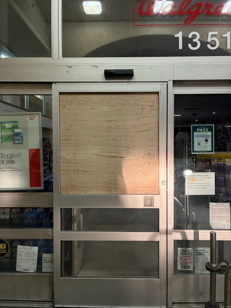 Emergency board-up covering a damaged commercial glass door in West Sacramento